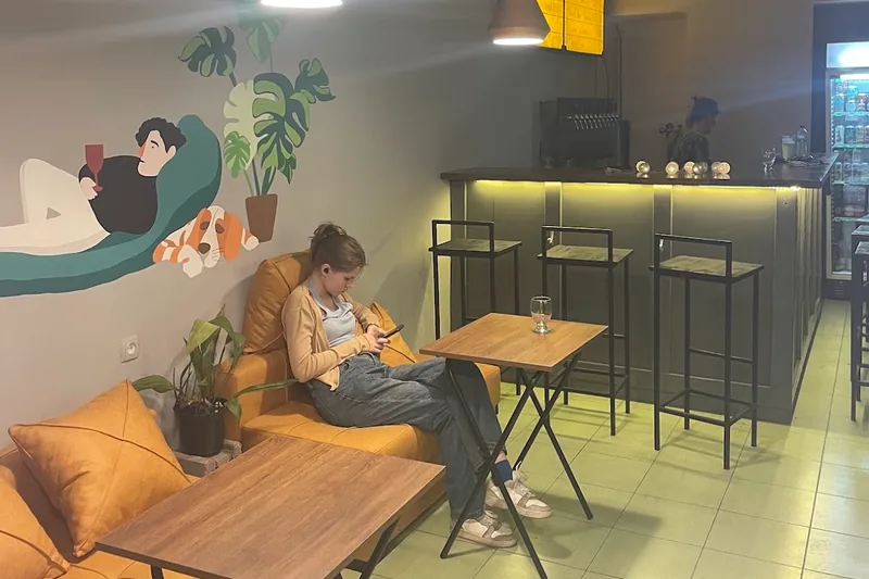 Yellow sofas, a painted mural and the bar counter at Optimist Craft Bar