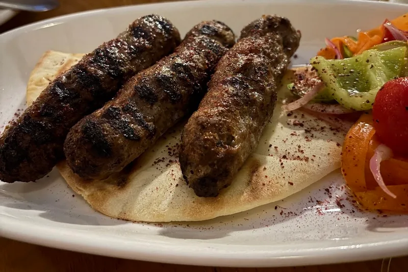 Grilled kebab skewers on flatbread with salad at ORO Marjanishvili