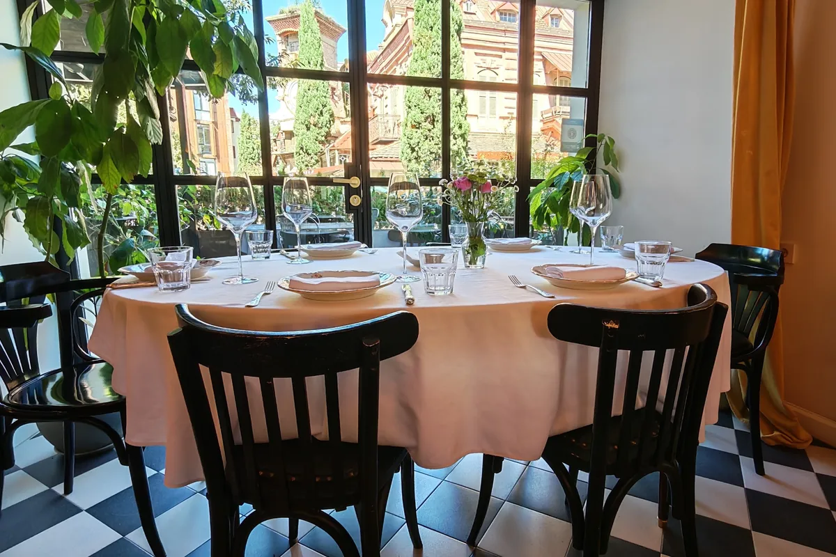 Set dining table with checkered floor and window view at OtsY