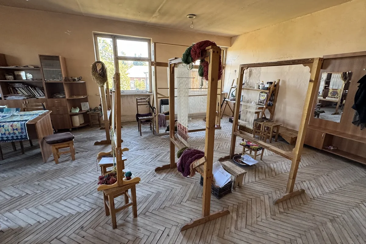 Wooden upright looms strung with warp threads and skeins of dyed wool in the workroom at Pesvebi Art Studio in Dedoplistskaro