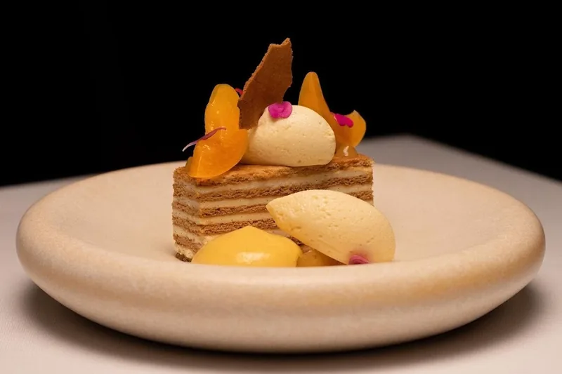 Layered honey cake dessert with sorbet and fruit at Reserve Restaurant