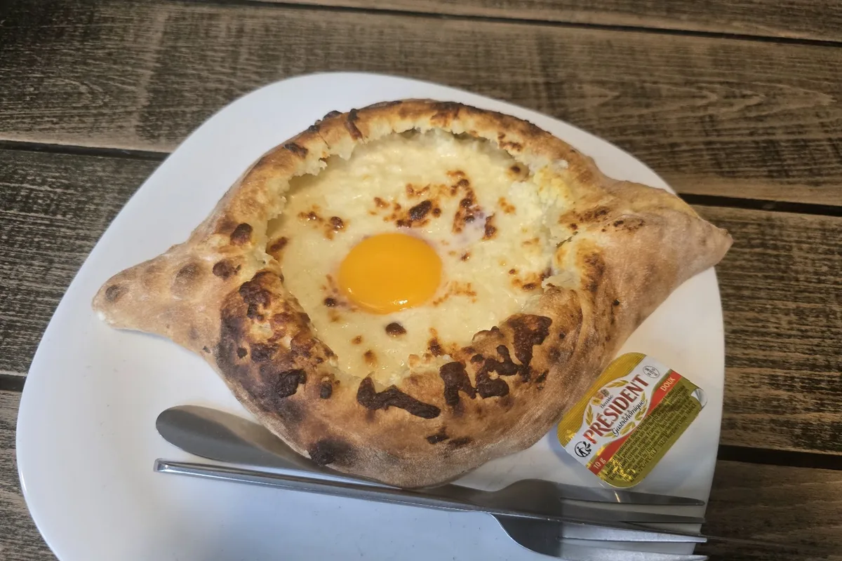 Adjaruli khachapuri with an egg yolk in the middle of the melted cheese at Retro in Saburtalo, Tbilisi