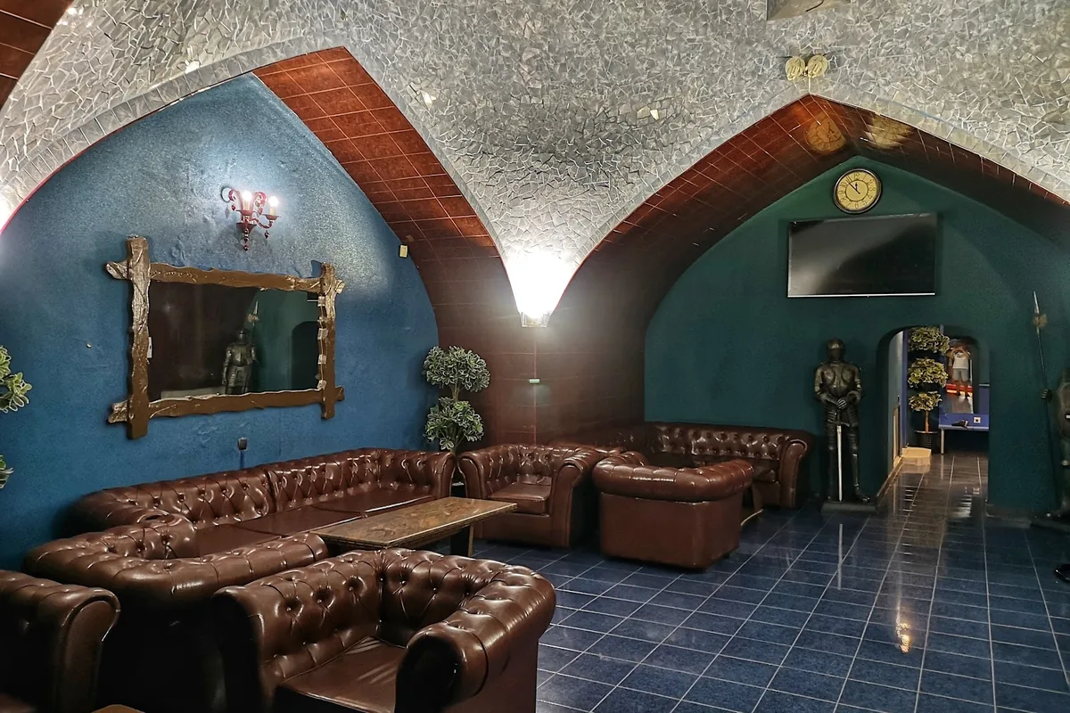 Lounge under a mosaic vault with leather sofas at Royal Bath