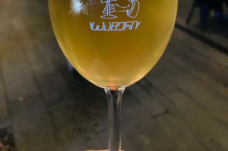 A glass of white wine in a printed wine glass at Saamuri Natural Wine Bar & Shop
