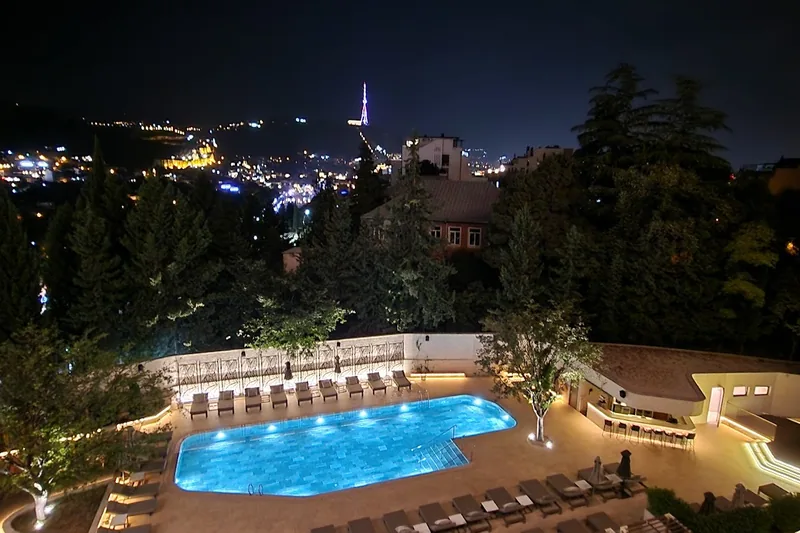 Outdoor pool lit up at night at the Sheraton Grand Tbilisi Metechi Palace in Avlabari