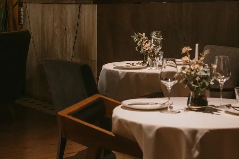 Dining tables with backlit arched bar shelves in background at St.Bunny