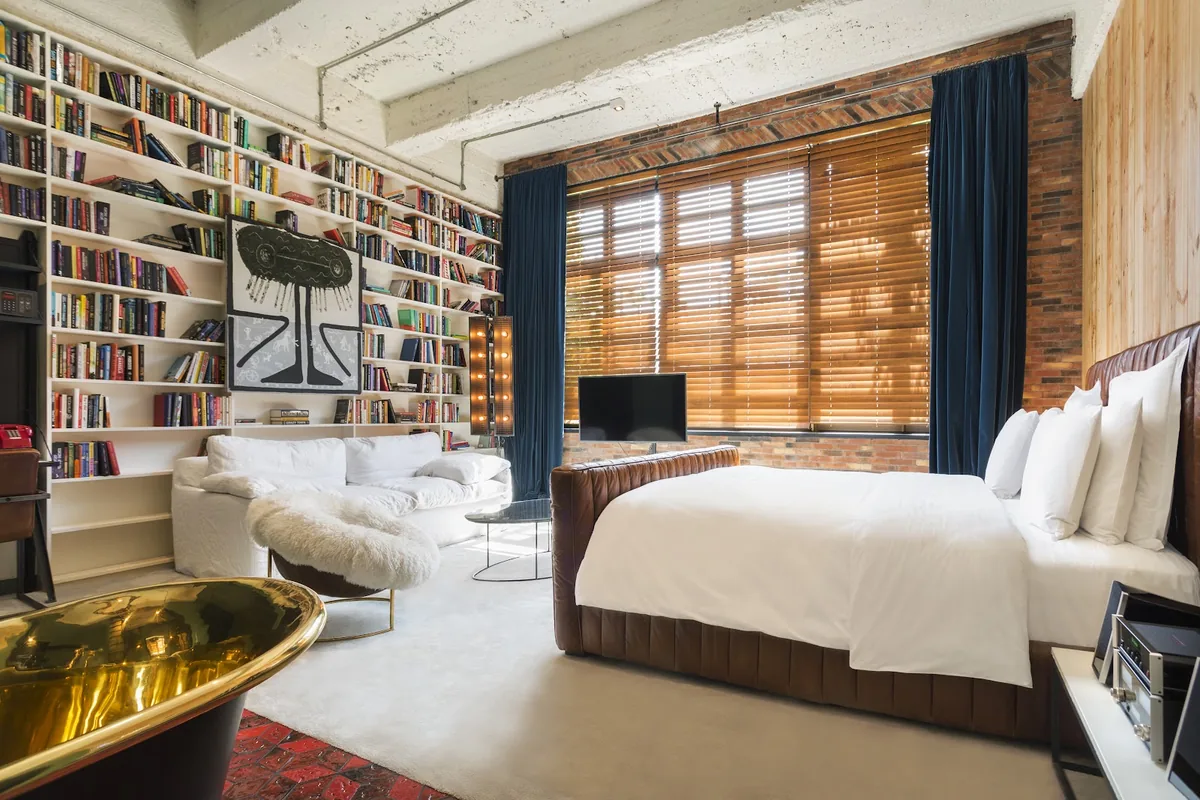 Guest room with a library wall at Stamba Hotel