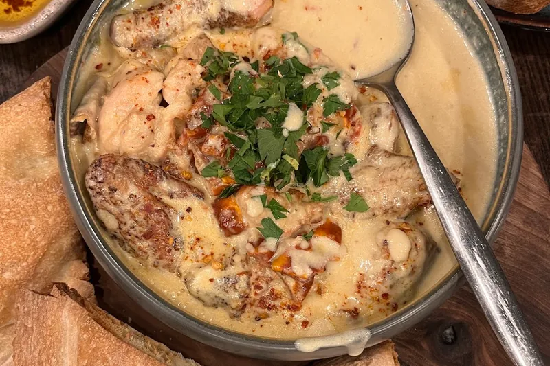 Shkmeruli chicken in creamy garlic sauce with bread at Sulico Wine Restaurant