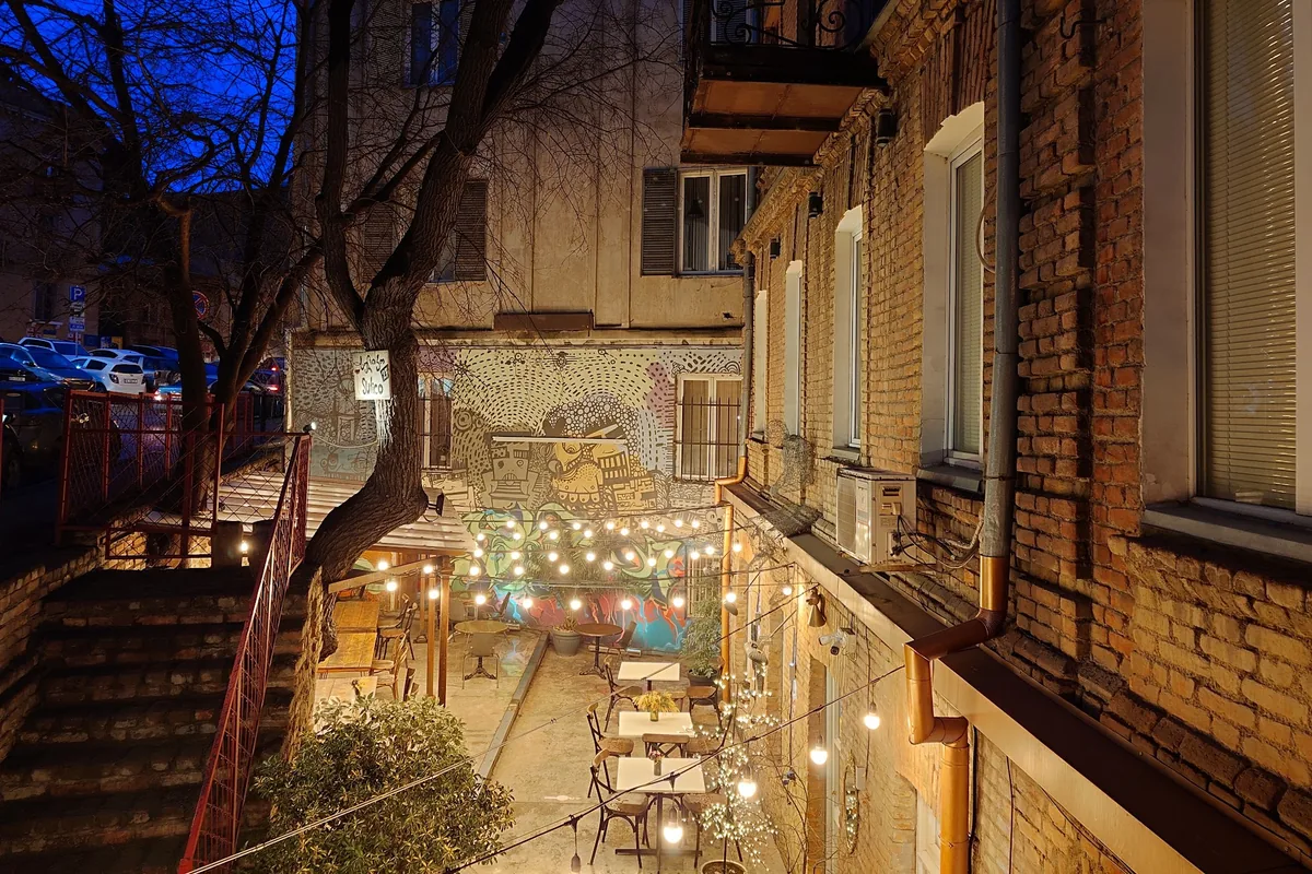 Courtyard patio with string lights and murals at dusk at Sulico Wine Restaurant