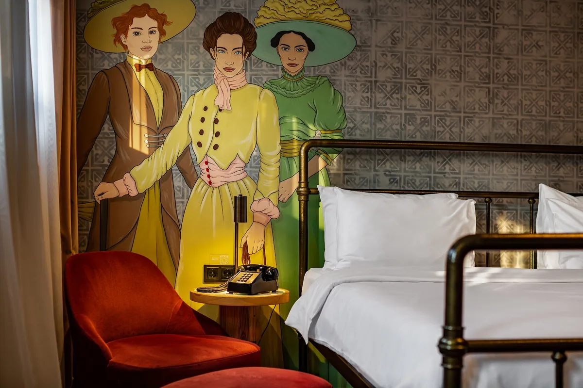 Guest room with a painted mural and an iron bed at The House Hotel Old Tbilisi