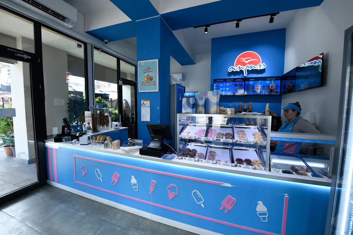 A Tolia parlor counter with the seagull logo and an ice cream and donut display