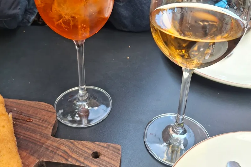 A spritz and a glass of white wine on a table at Tone in Fabrika