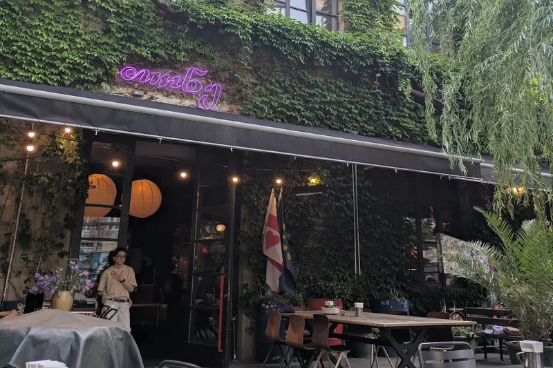 Ivy-covered facade and terrace tables at Tone in the Fabrika courtyard