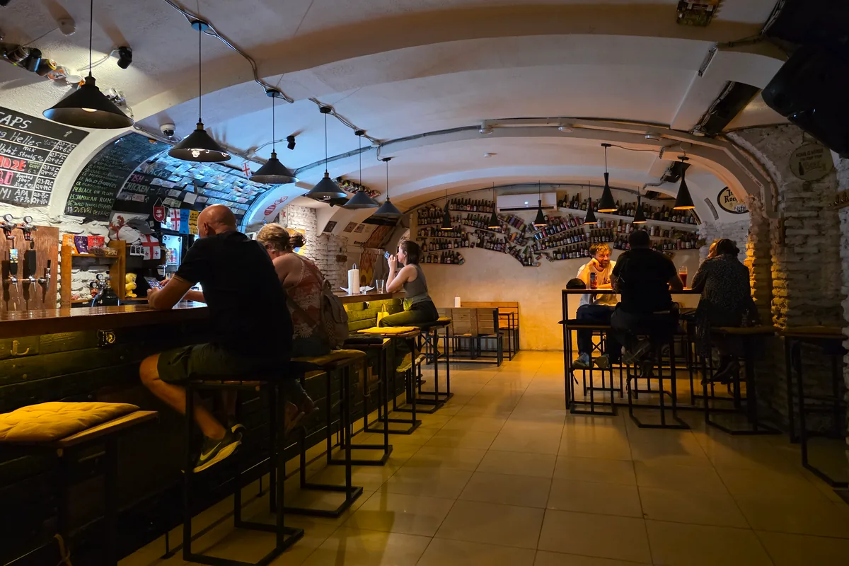 Vaulted craft beer bar with taps and a chalkboard beer list at Tsota Tsota