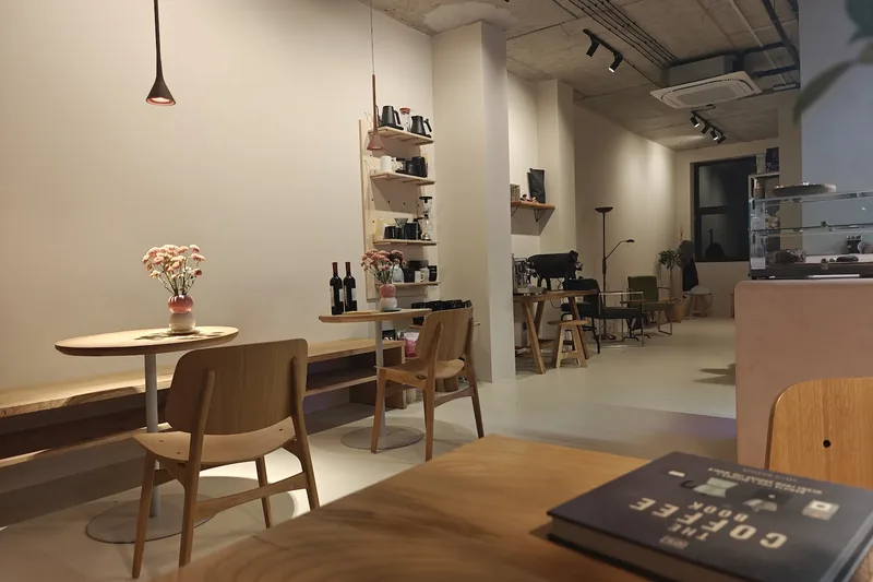 Wooden tables in the white-walled cafe room at Tsvari Roasters on Ninoshvili Street