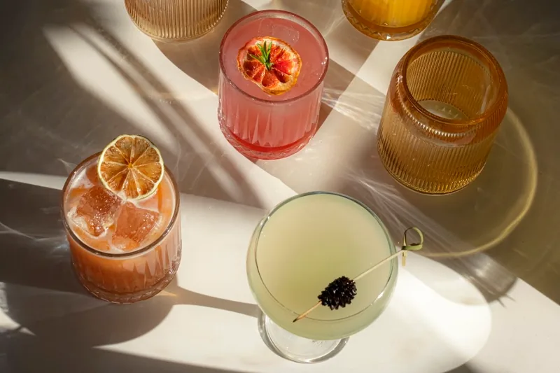 Assortment of cocktails on a sunlit table at Unfound Door