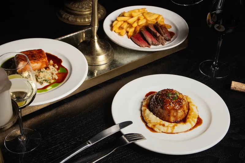 Dinner spread with steak frites, salmon and meatballs over mash at Unfound Door
