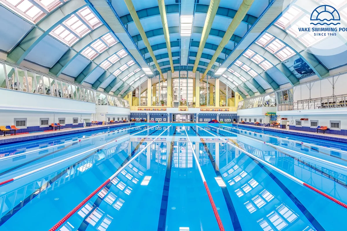 The 50 m indoor pool under the arched glass roof at Vake Swimming Pool