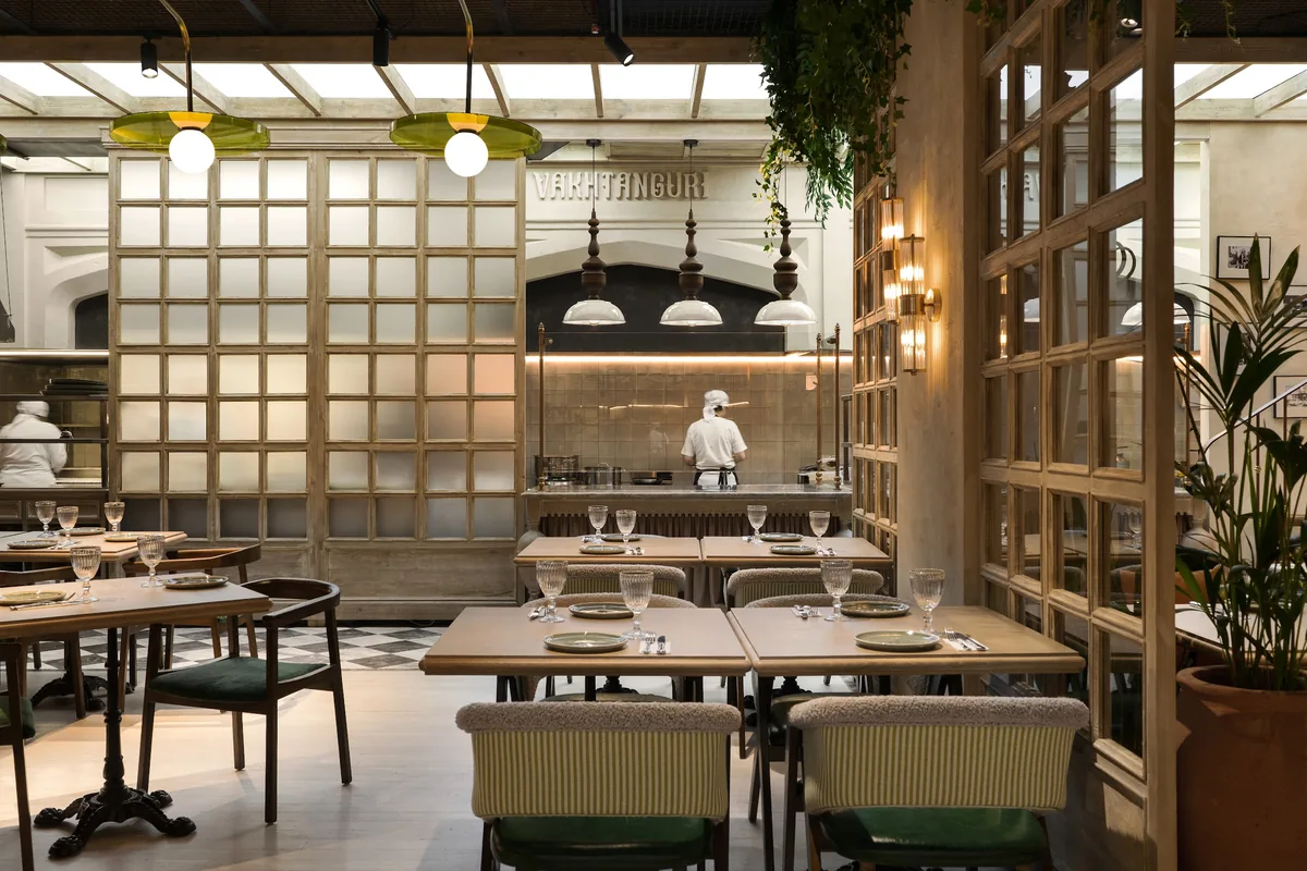 Dining room with wooden lattice partitions and tables at Vakhtanguri