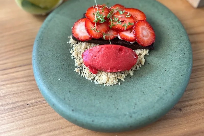 Chocolate dessert topped with sliced strawberries and sorbet at Van Goghi