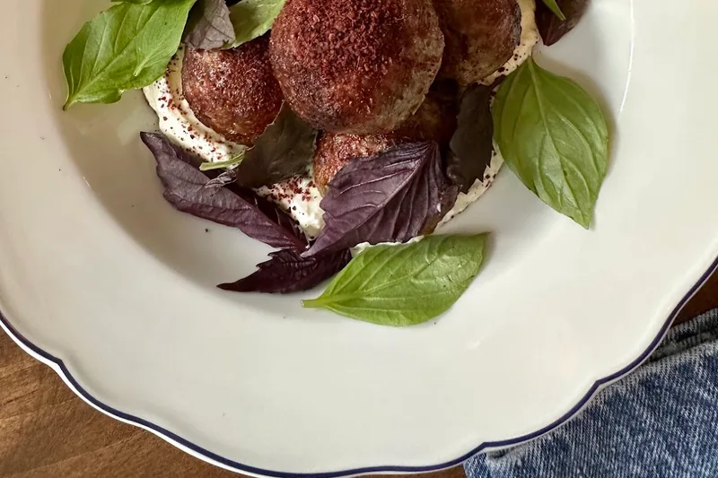 Meatballs with flatbread and basil over yogurt sauce at Veriko