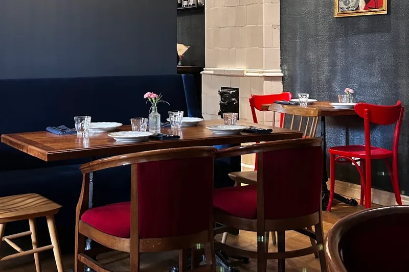 Dining room with chandelier and red velvet chairs at Veriko