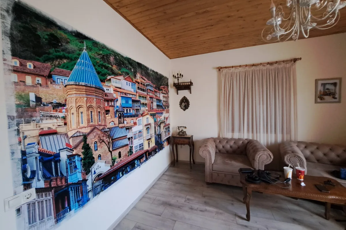 Room with a mural of old Tbilisi and leather armchairs at Vintage Art Rooms