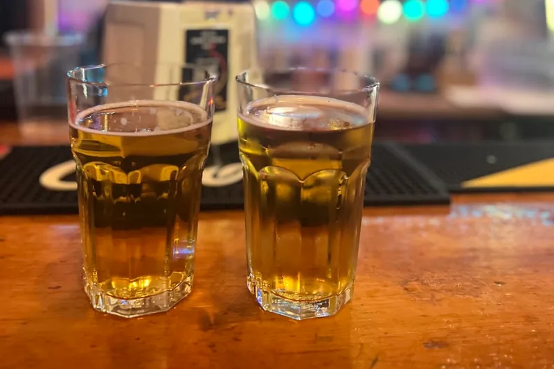 Two glasses of beer on the wooden bar counter at Warszawa