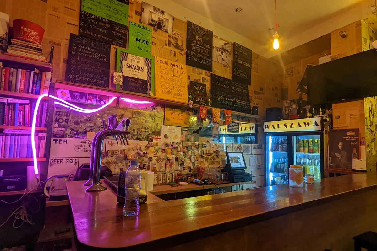 Wooden bar counter and taps with menu boards at Warszawa