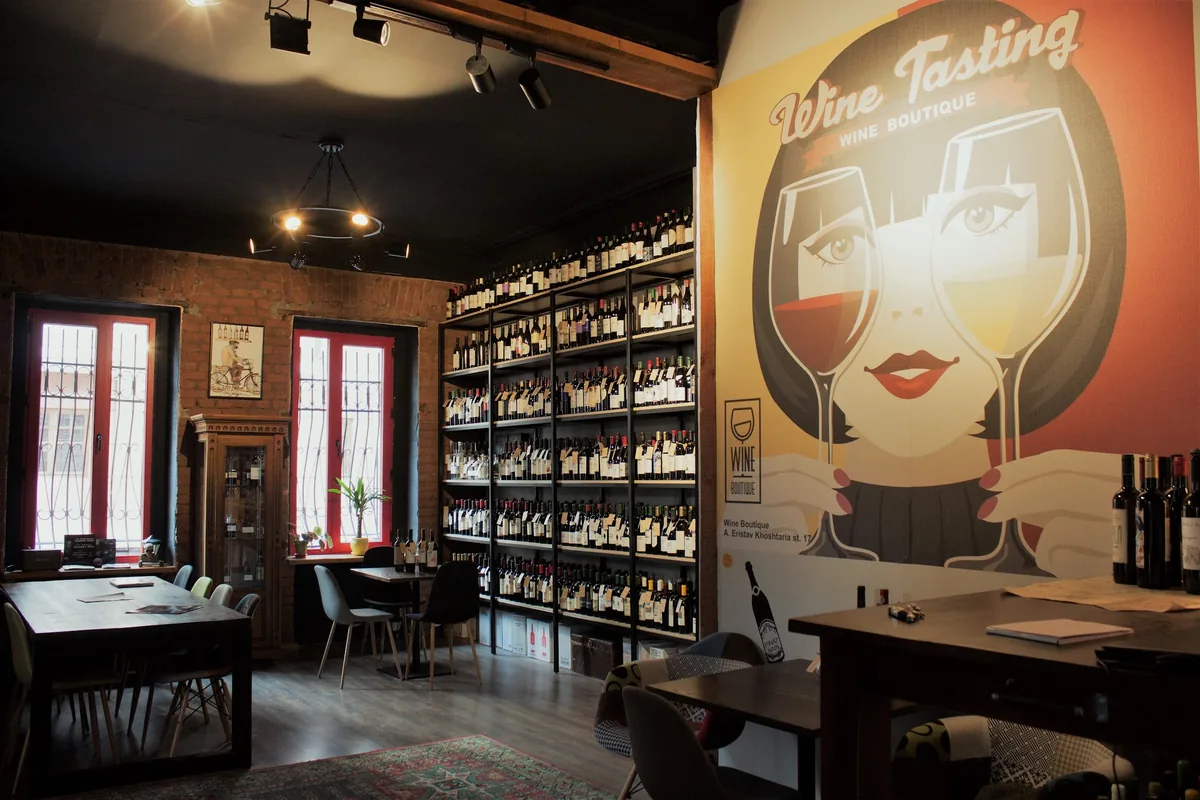 Wine tasting room with bottle shelves and mural at Wine Boutique