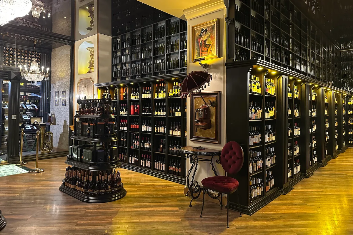 Tall black shelves stacked with wine bottles inside Wine Gallery in Marjanishvili