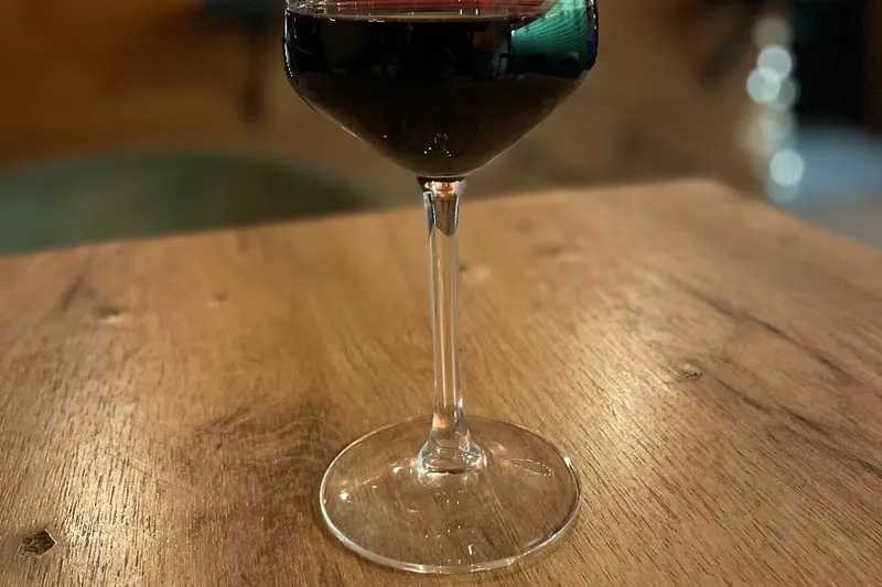Glass of red wine on a wooden table at Wine Not?