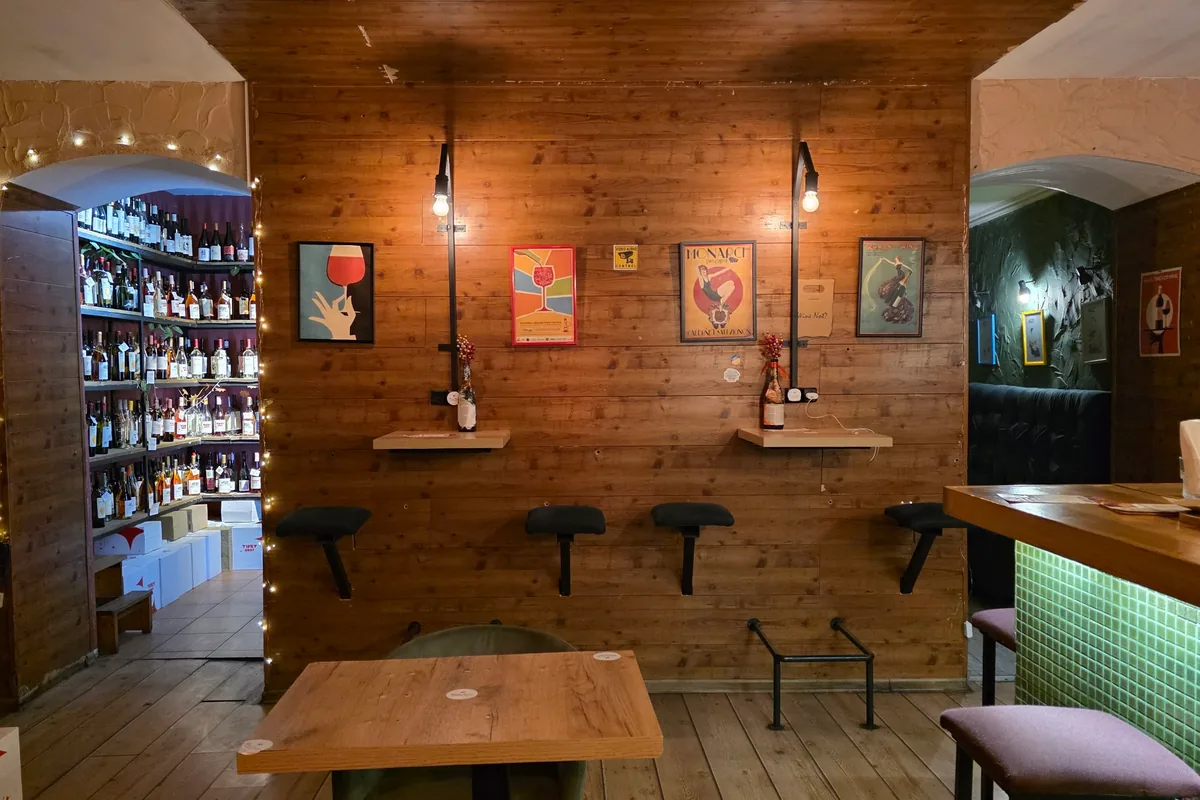 Wood-panelled seating area with wine shop alcove at Wine Not?