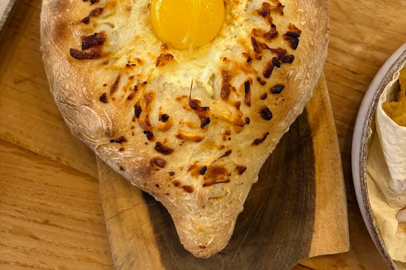 Adjarian khachapuri on a wooden board at WineCode