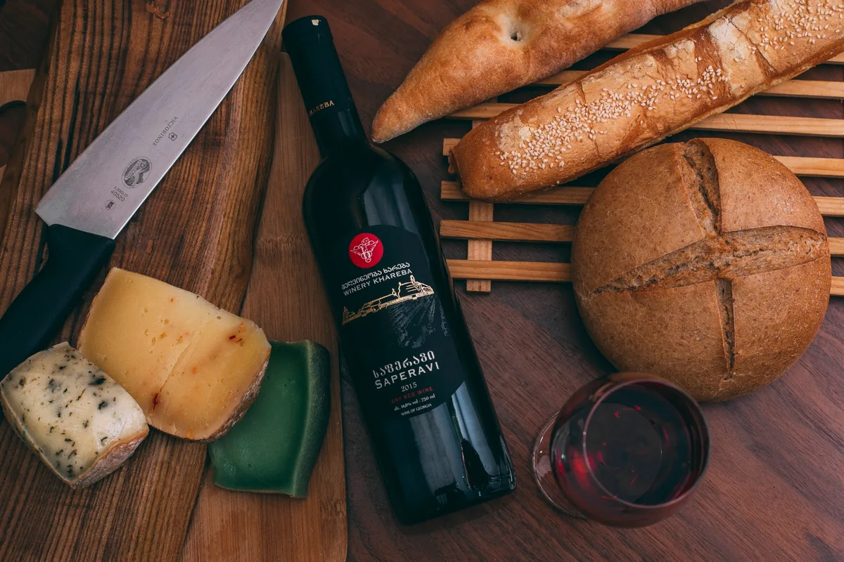Bottle of Winery Khareba Saperavi red wine with bread and cheese