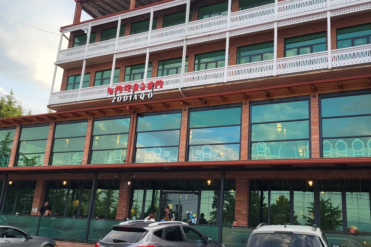 The brick front of Zodiaqo in Telavi with its white wooden balconies and glass-walled dining rooms