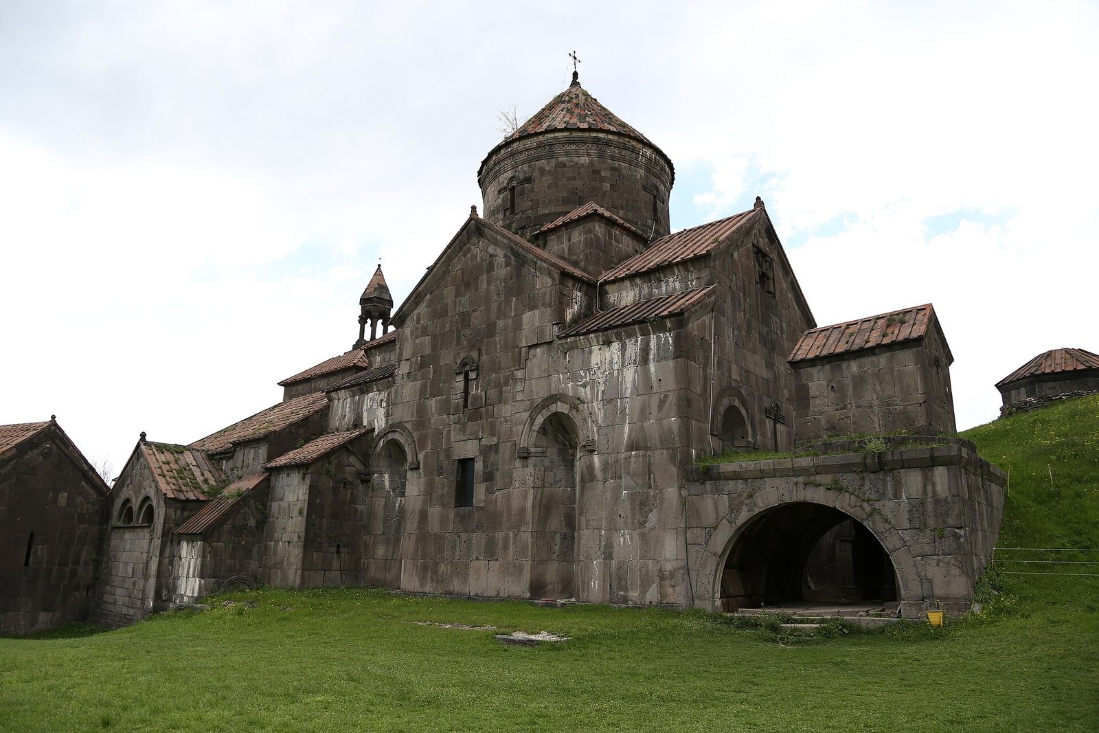 The stone domes and arched gavit of Haghpat Monastery on a green hillside in northern Armenia