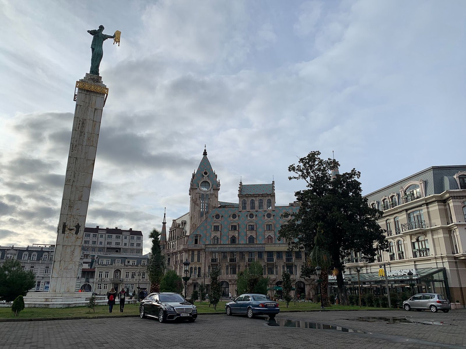 The Medea statue holding the Golden Fleece on its tall column in Europe Square, Batumi, with the square's old buildings behind