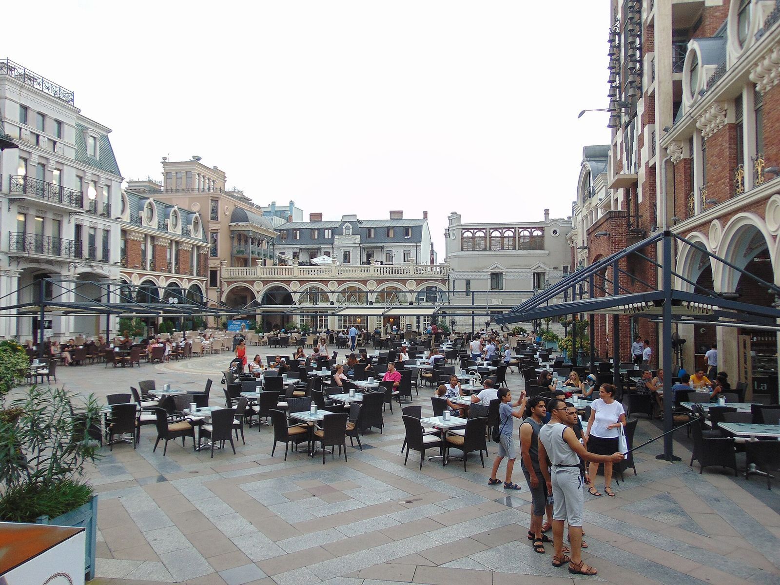 Cafe tables filling the Piazza in Old Batumi, ringed by ornate buildings with arcades and balconies