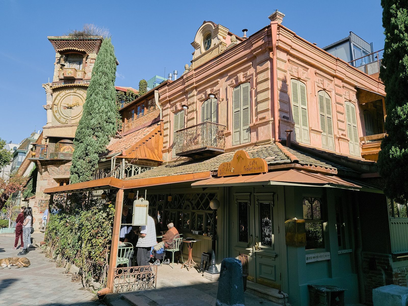 Café Gabriadze with its sign and covered terrace, beside the leaning Gabriadze clock tower