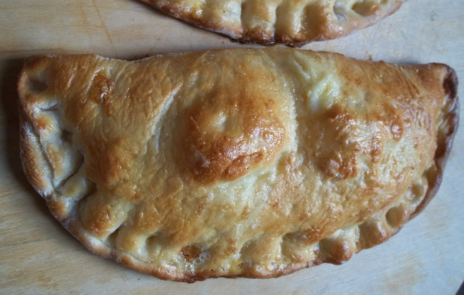 Guruli khachapuri, the crescent-shaped Gurian cheese and egg pastry, with a golden glazed crust