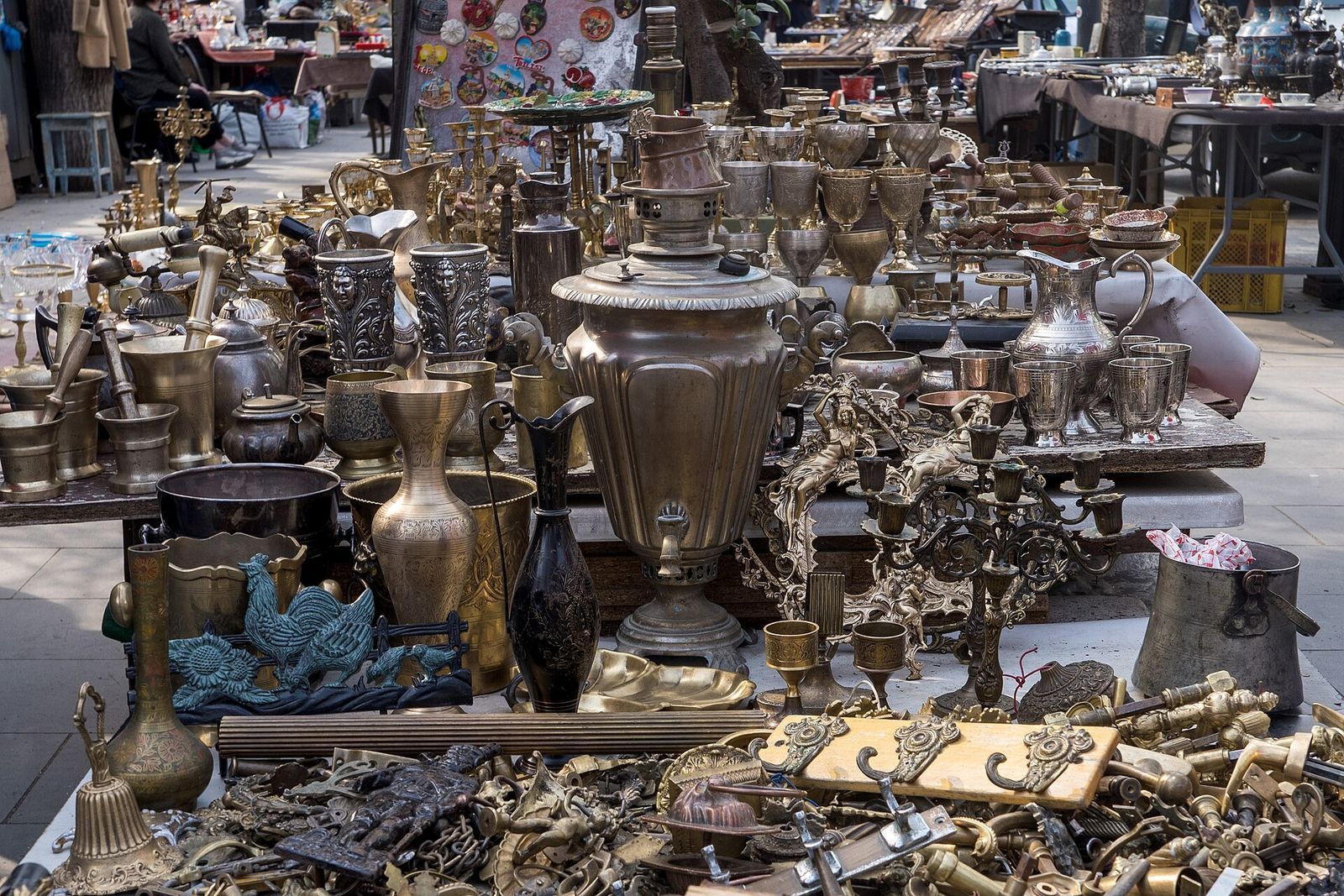 Brass samovars, jugs and candlesticks laid out on a stall at the Dry Bridge Market
