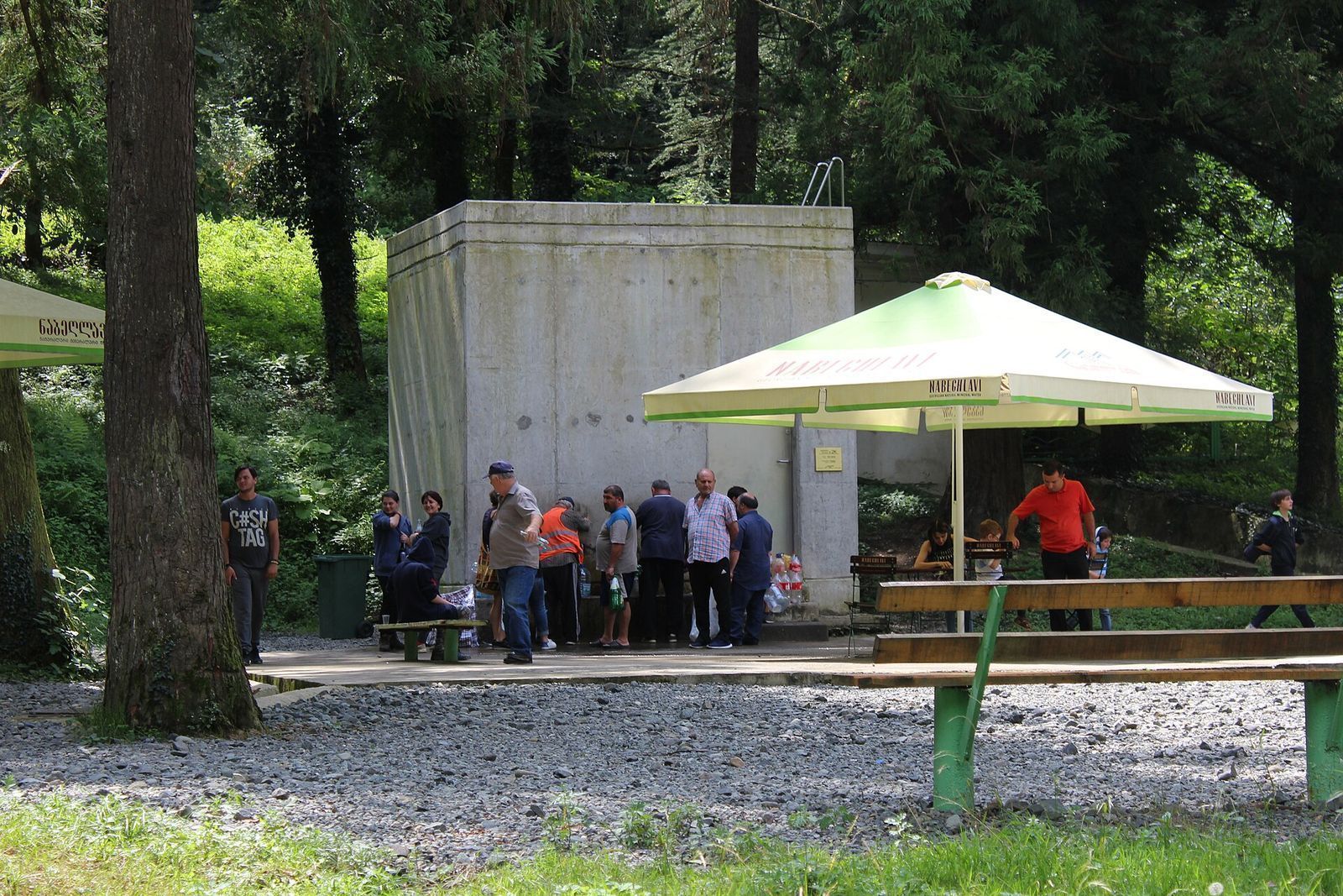 People waiting to fill bottles at the Nabeghlavi mineral water spring house in the forest