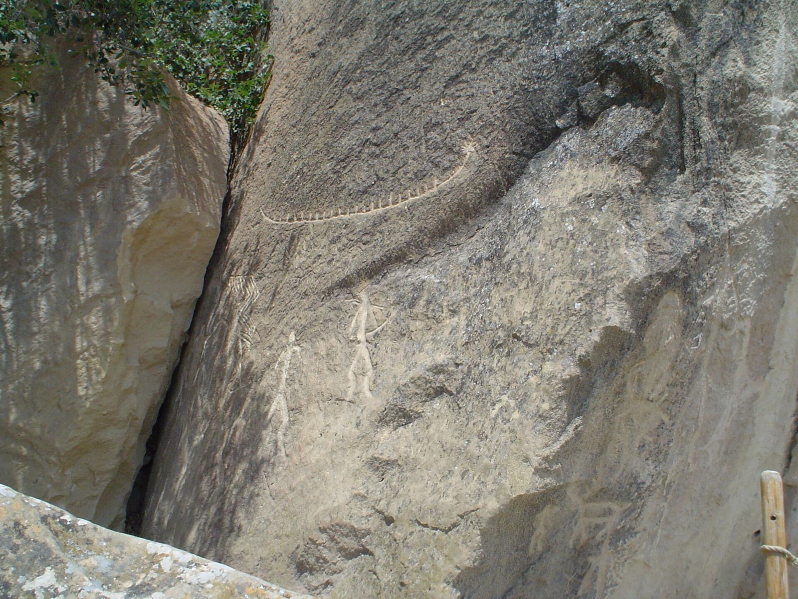 Ancient carvings of human figures and a long reed boat on a boulder at Gobustan, Azerbaijan
