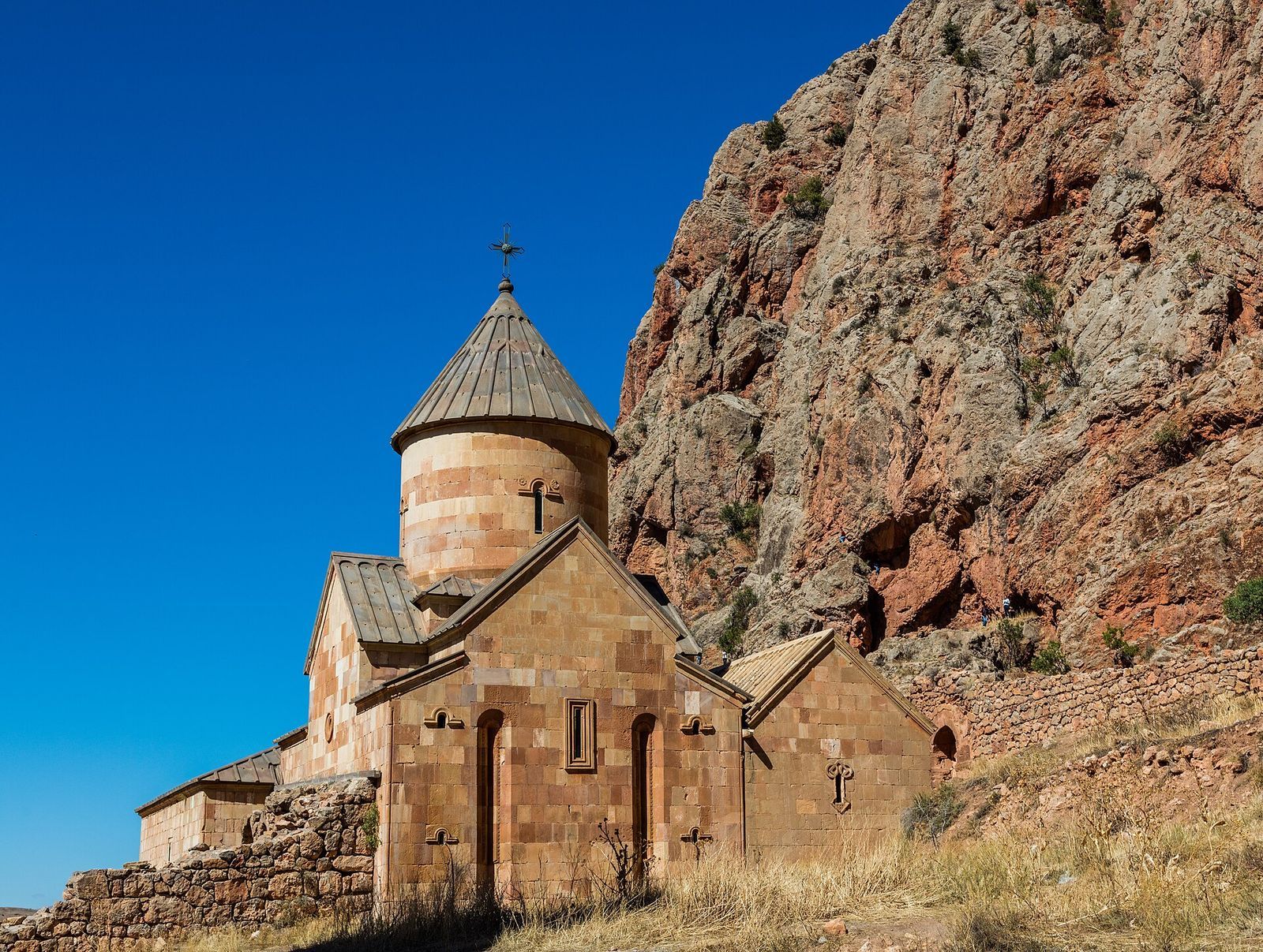 The Surb Karapet church of Noravank Monastery below red cliffs in southern Armenia
