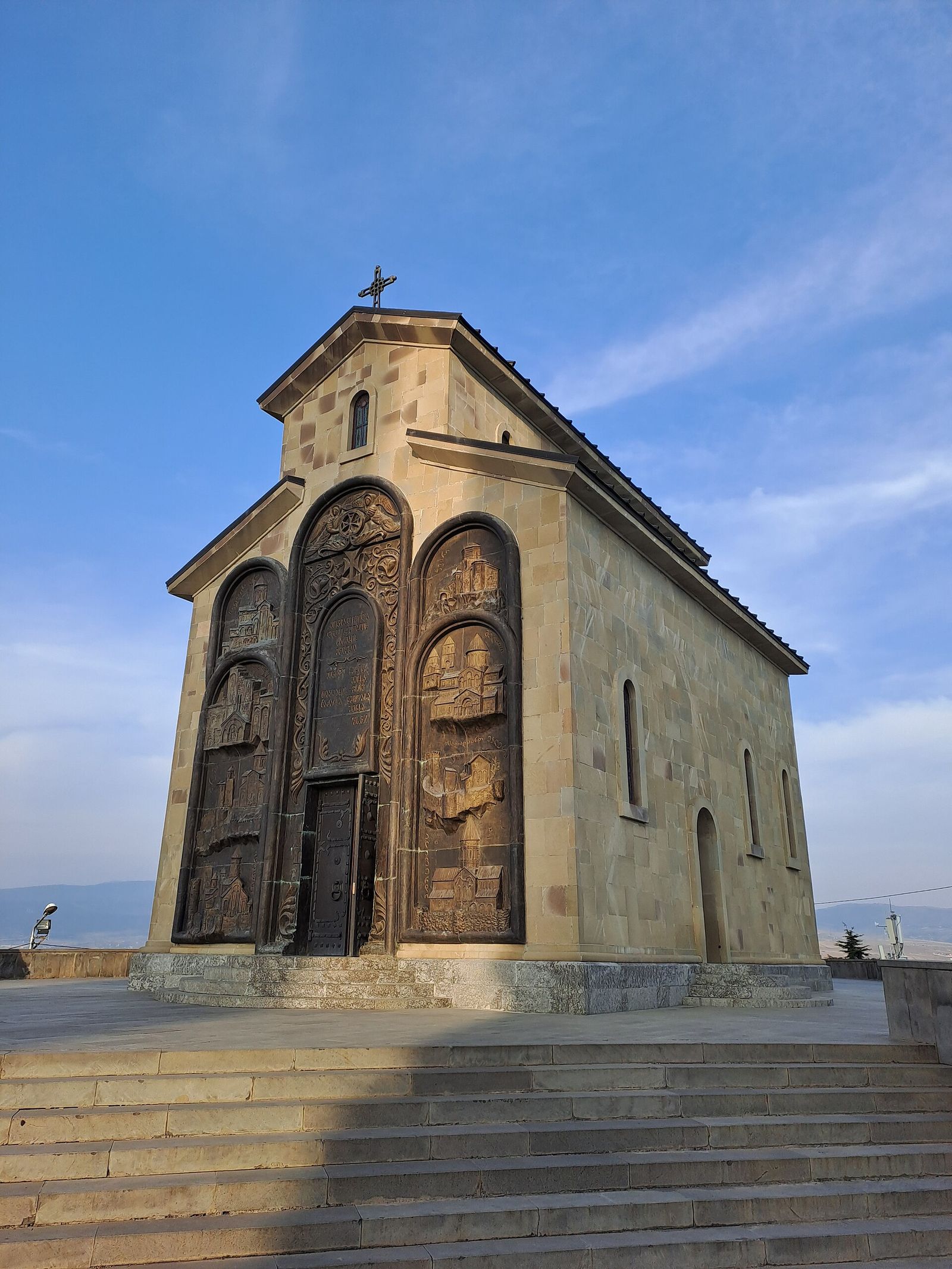 The Church of the Annunciation at the Chronicles of Georgia, its front covered in bronze reliefs set in three tall arches