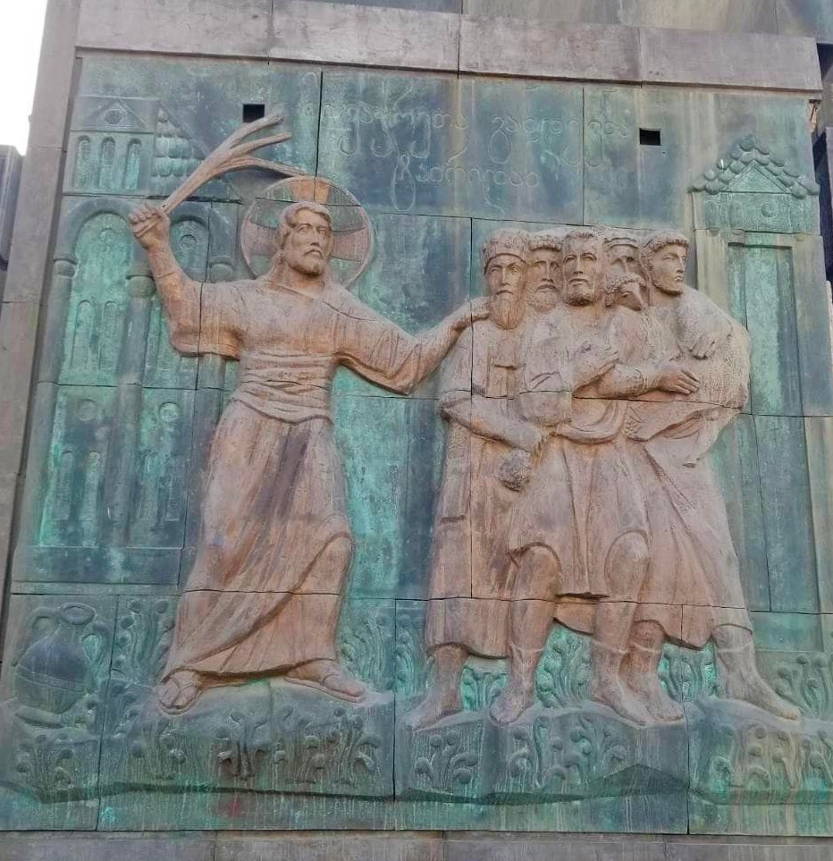Bronze relief of Christ with a raised branch driving back a group of men, one of the life-of-Christ scenes on a Chronicles of Georgia pillar
