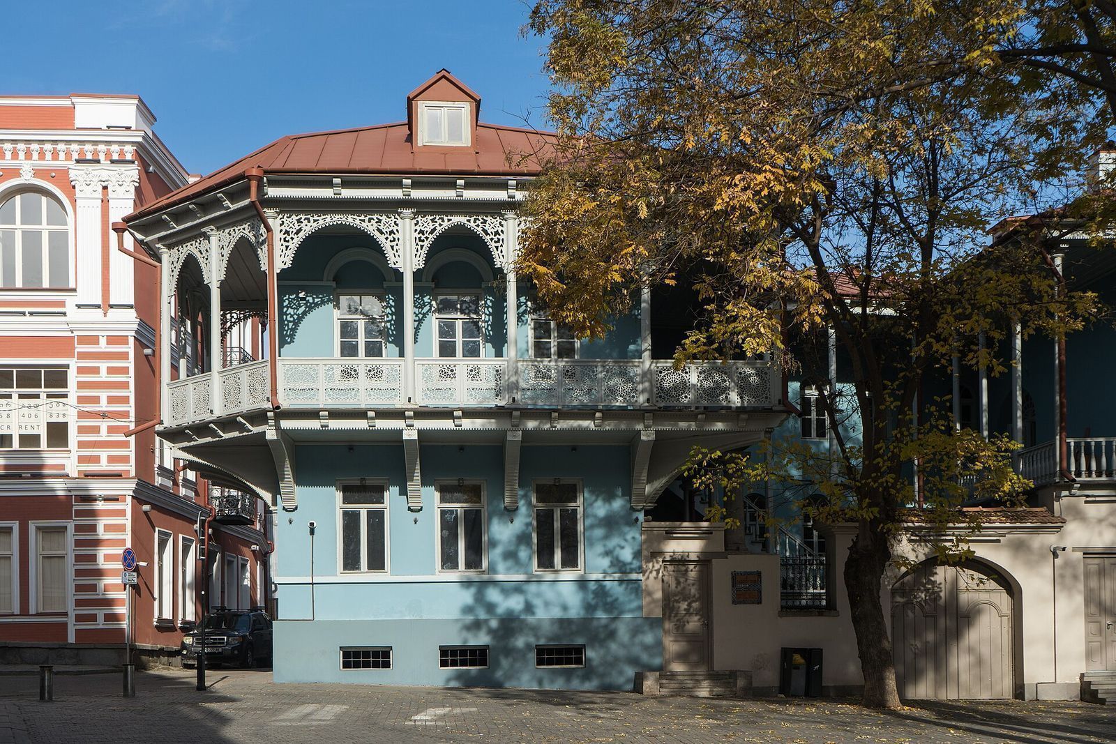 A traditional blue house with carved wooden balconies on Gudiashvili Square in Tbilisi