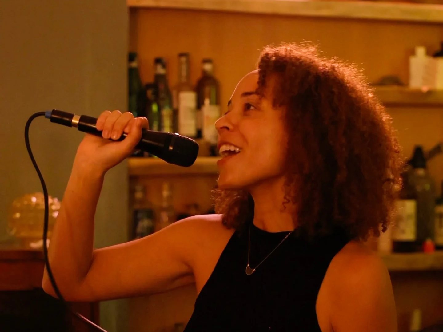 A singer with a microphone on karaoke night at Crossroads Bar