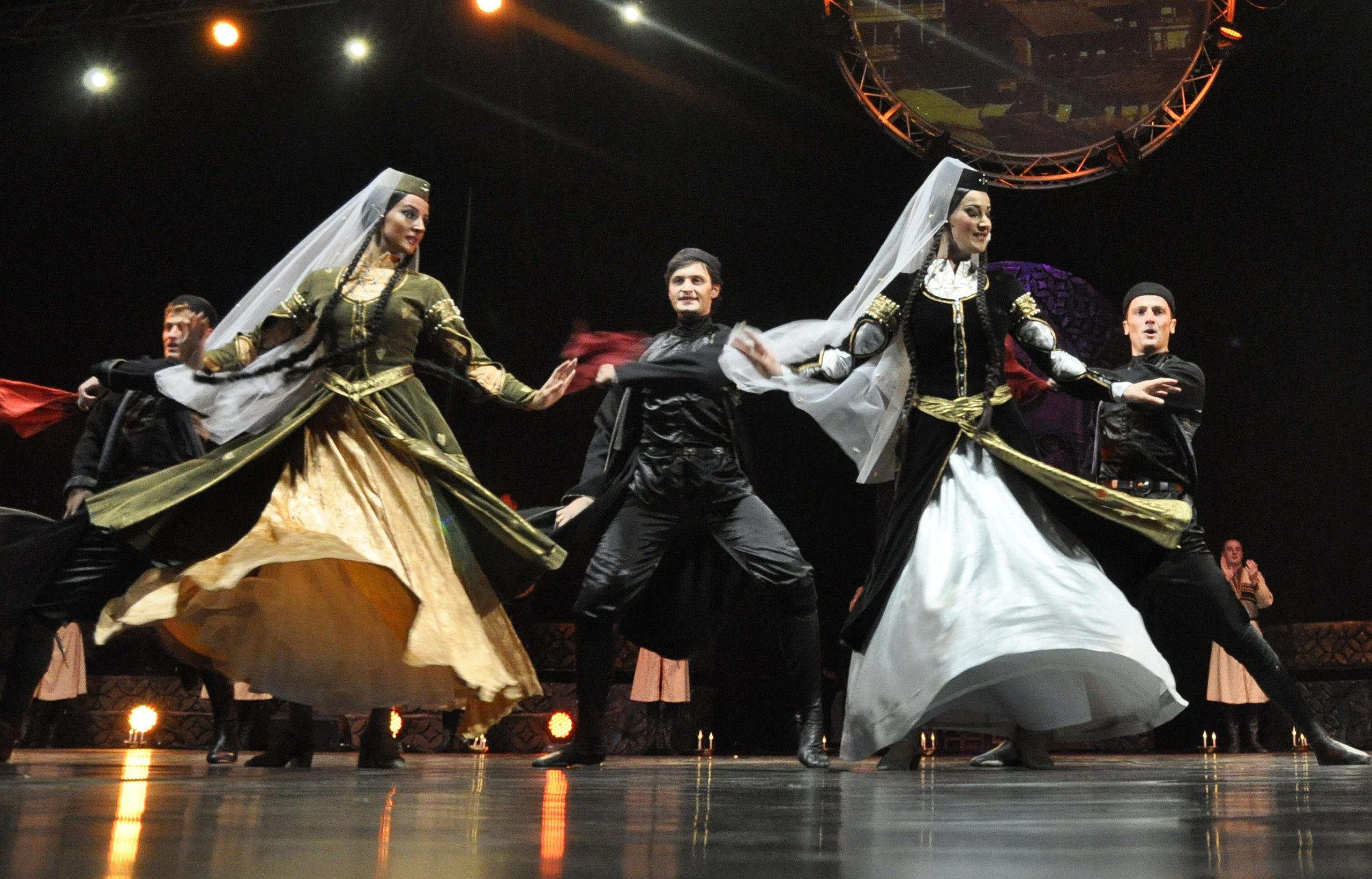 Dancers of the Erisioni ensemble on stage in traditional Georgian costume